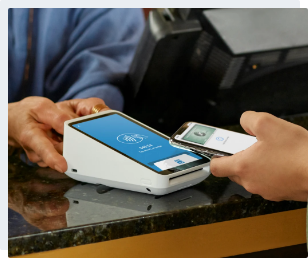Customer paying with phone and Square payment terminal